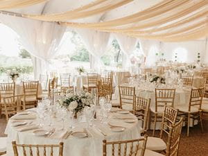 Formal wedding reception under outdoor tent 